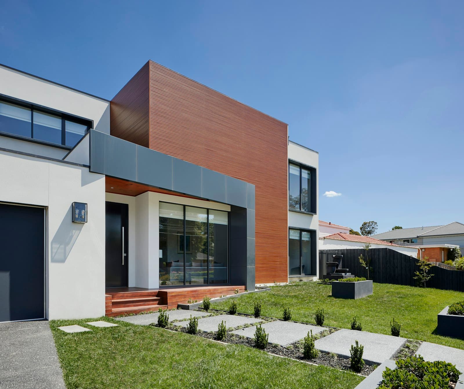 Contemporary two-storey family house with timber and white facade